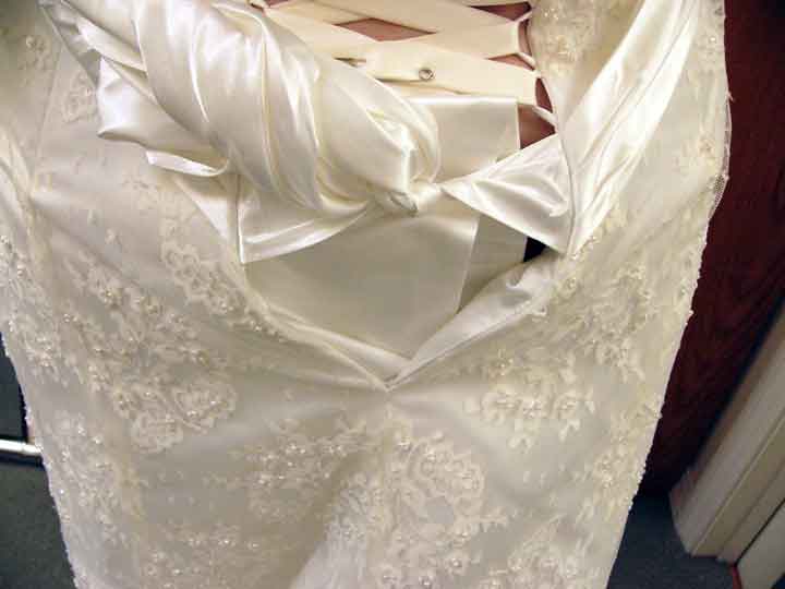 Adding ribbon to the back.  Wedding dress alterations, Wedding